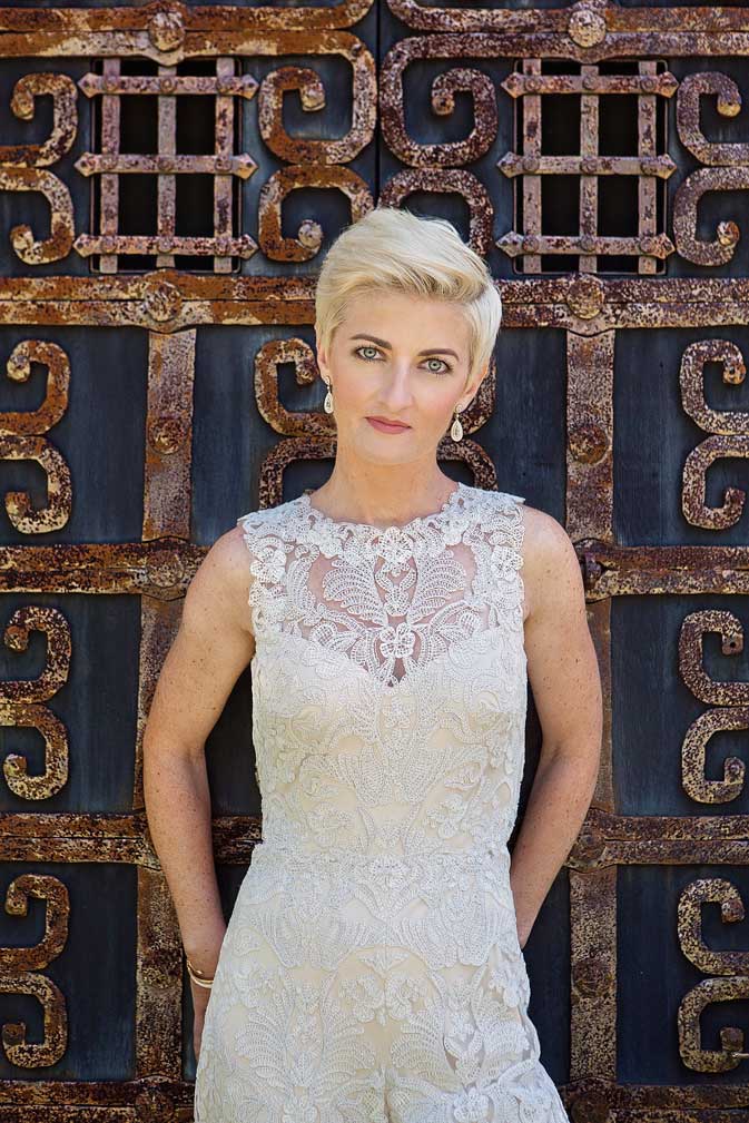 lesbian bride with short blonde hair in ivory lace BHLDN jumpsuit