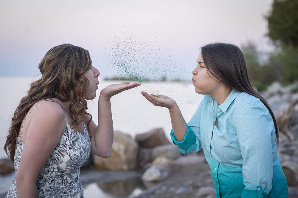 Ontario orchard engagement photography shoot blowing a kiss lesbian