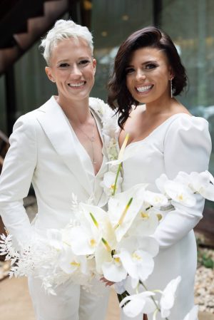 two brides pose together on their wedding day