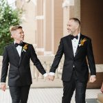 two grooms smiling and holding hands