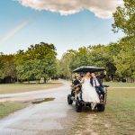 an LGBT couple riding away on a golf cart