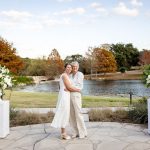 two brides hug one another at their wedding