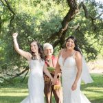 a bride thrusts her hand in the air after getting married