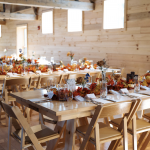 Handcrafted farm tables and wooden banquet chairs for up to 250 guests are included