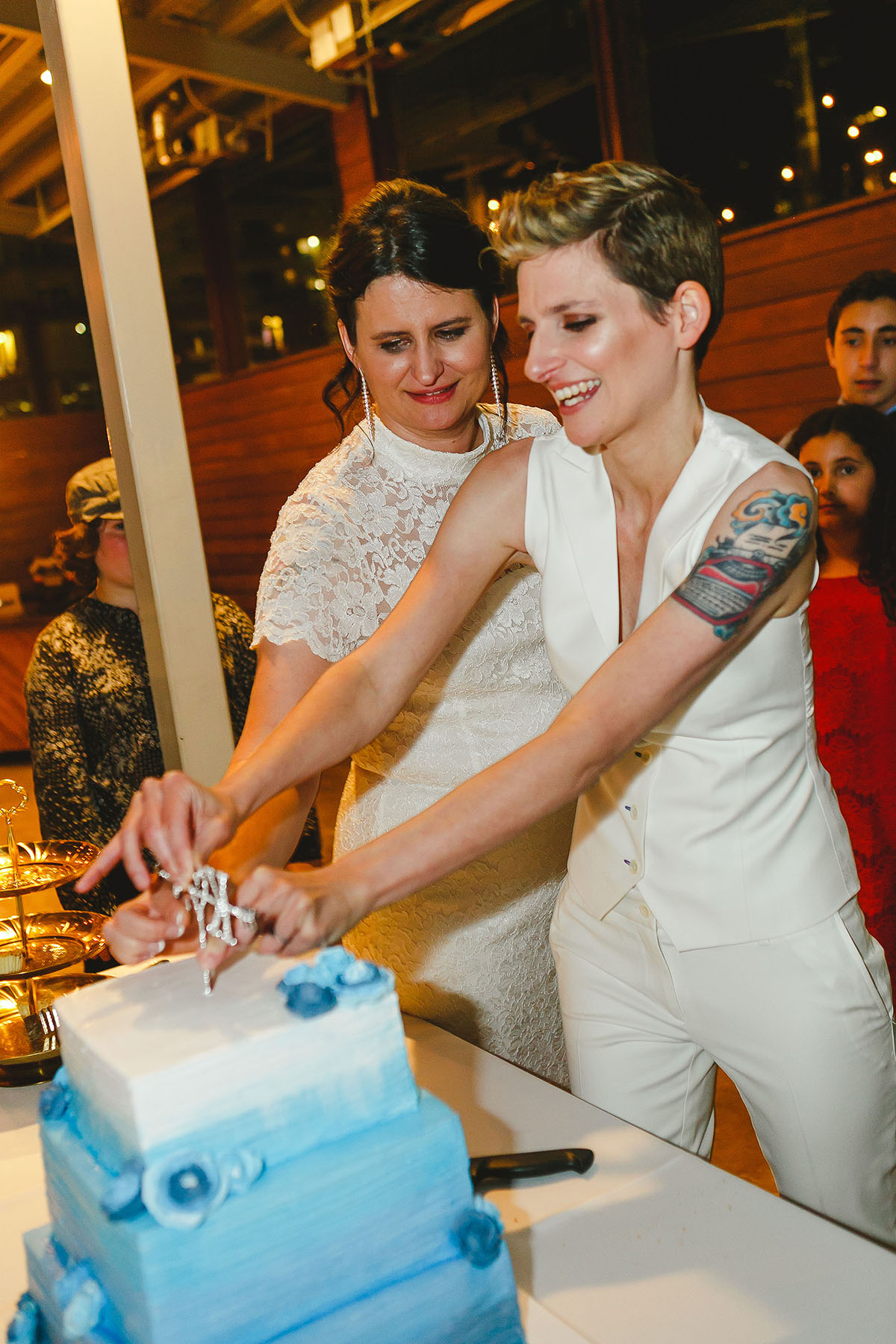 Colorful outdoor rooftop lesbian wedding in Austin, Texas cutting cake