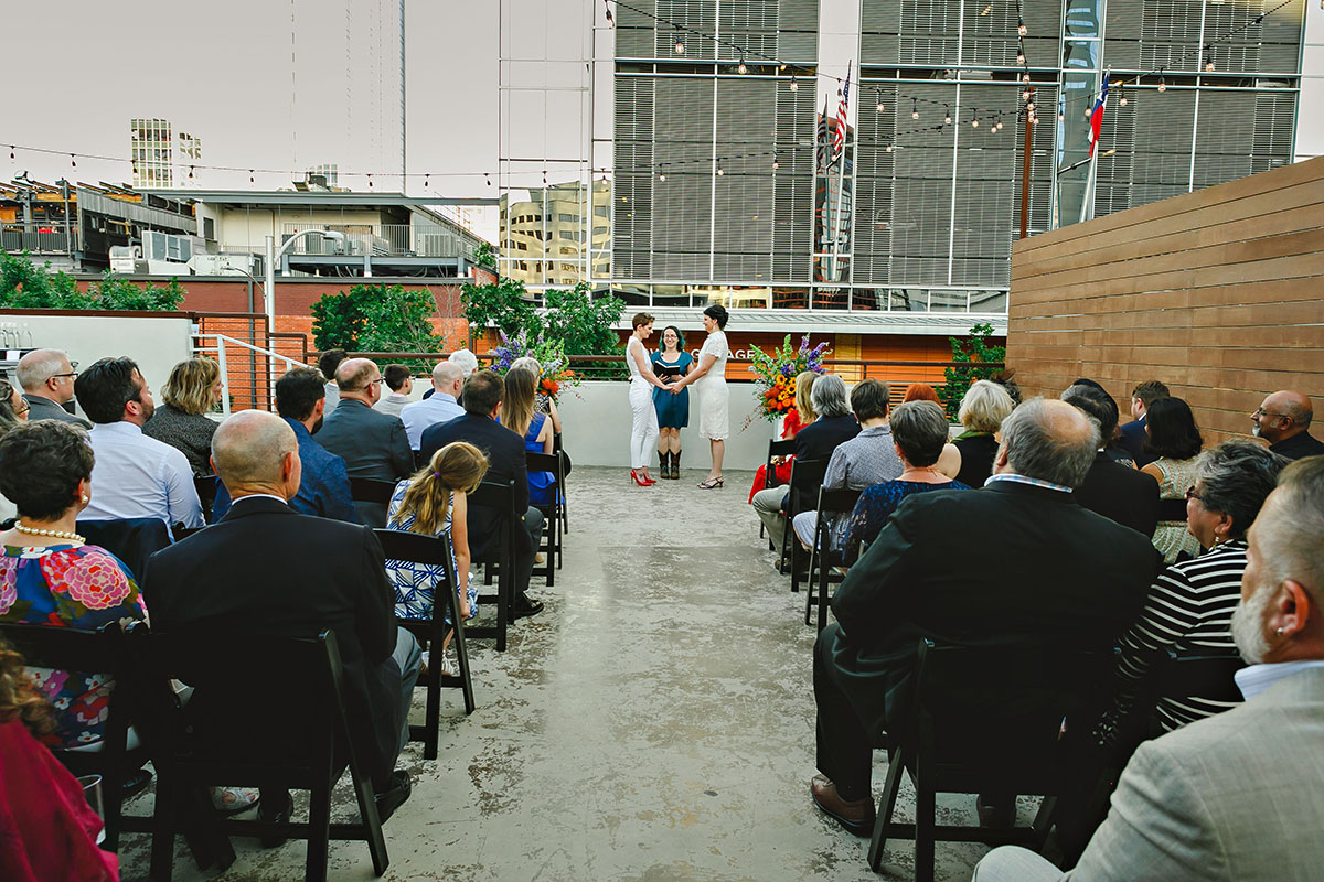 Colorful outdoor rooftop lesbian wedding in Austin, Texas ceremony