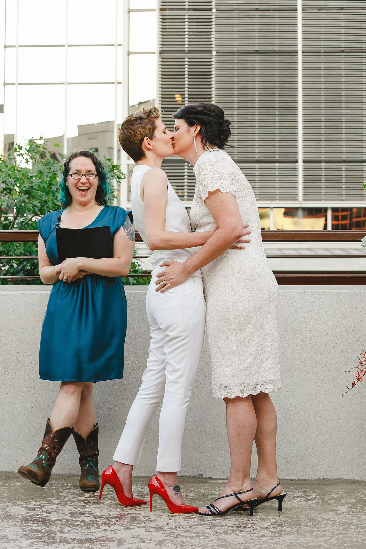 Colorful outdoor rooftop lesbian wedding in Austin, Texas kiss