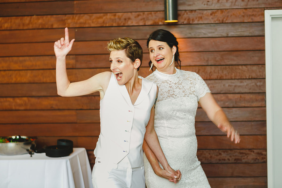 Colorful outdoor rooftop lesbian wedding in Austin, Texas happy laughing