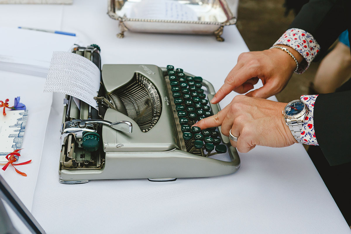 Colorful outdoor rooftop lesbian wedding in Austin, Texas vintage typewriter