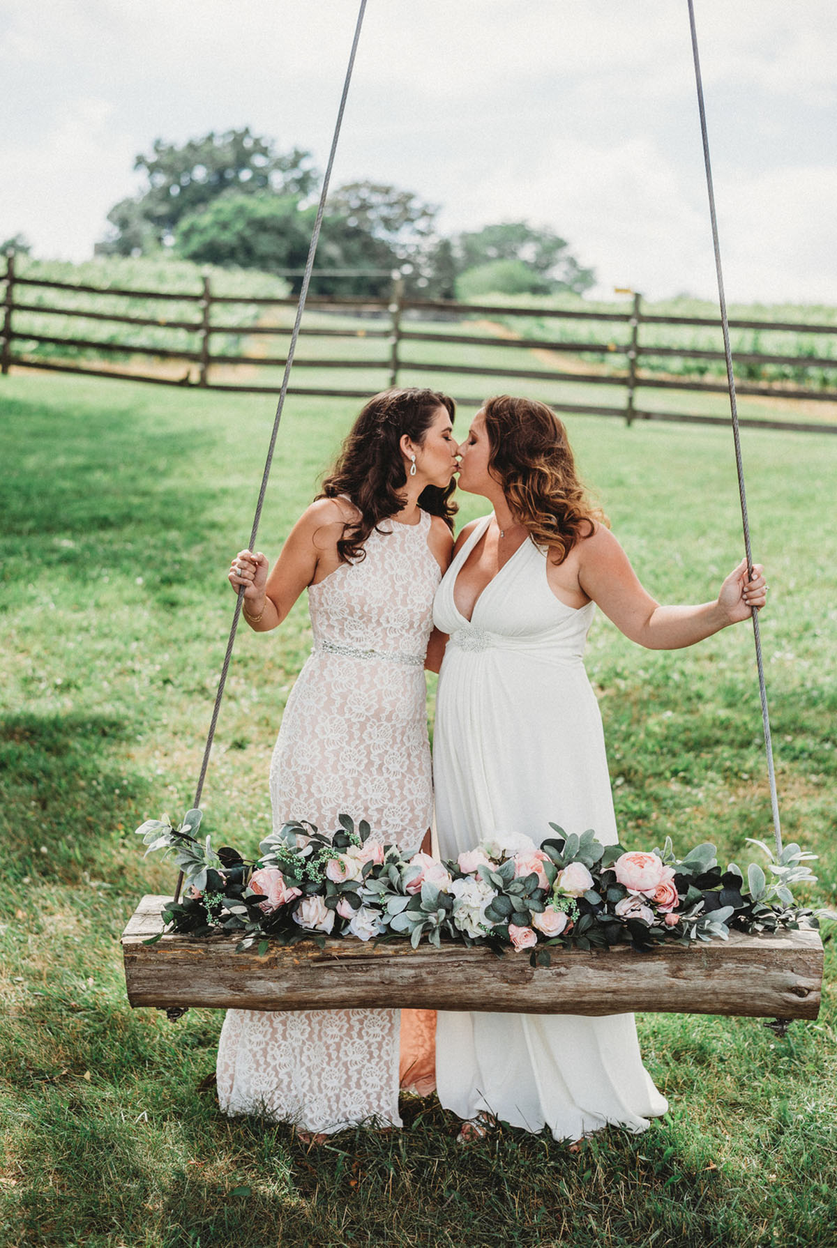 Two brides trash their wedding dresses in a styled shoot swingset kiss