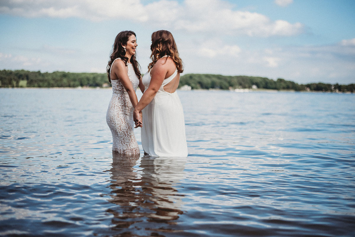 Two brides trash their wedding dresses in a styled shoot water