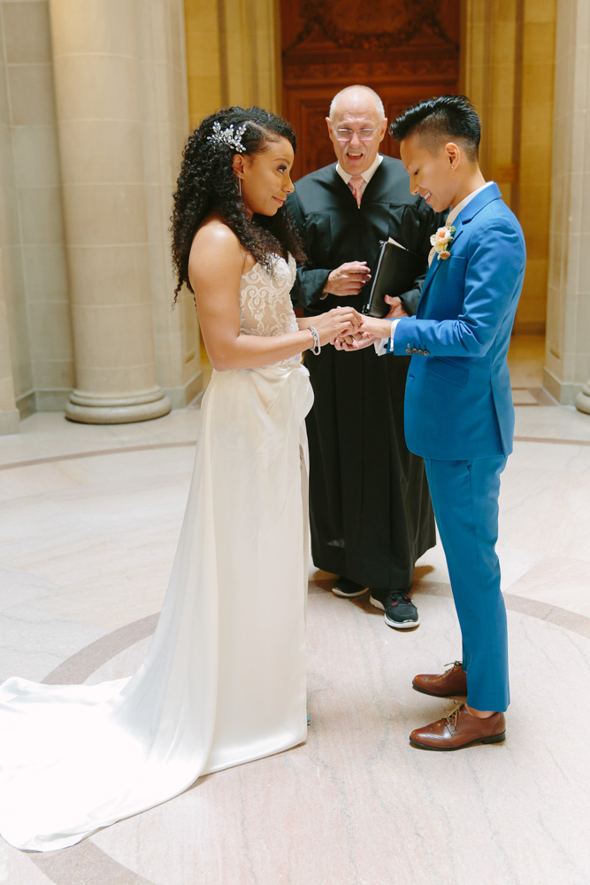 Actress Shalita Grant and commercial director Sabrina Skau married Aug. 8, 2018, in a San Francisco City Hall summer wedding. Shalita Grant wore a custom white gown with lace pants by Clara Diaz, and Sabrina Skau donned a custom blue suit from Bindle & Keep. Photography by Lilia Ahner. Featured on Equally Wed, a queer-owned LGBTQ+ wedding magazine.