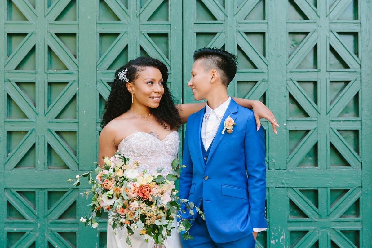 Actress Shalita Grant and commercial director Sabrina Skau married Aug. 8, 2018, in a San Francisco City Hall summer wedding. Shalita Grant wore a custom white gown with lace pants by Clara Diaz, and Sabrina Skau donned a custom blue suit from Bindle & Keep. Photography by Lilia Ahner. Featured on Equally Wed, a queer-owned LGBTQ+ wedding magazine
