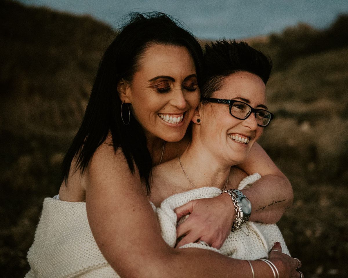 Same-sex engagement photography session on the coast of South Australia hugs sunset