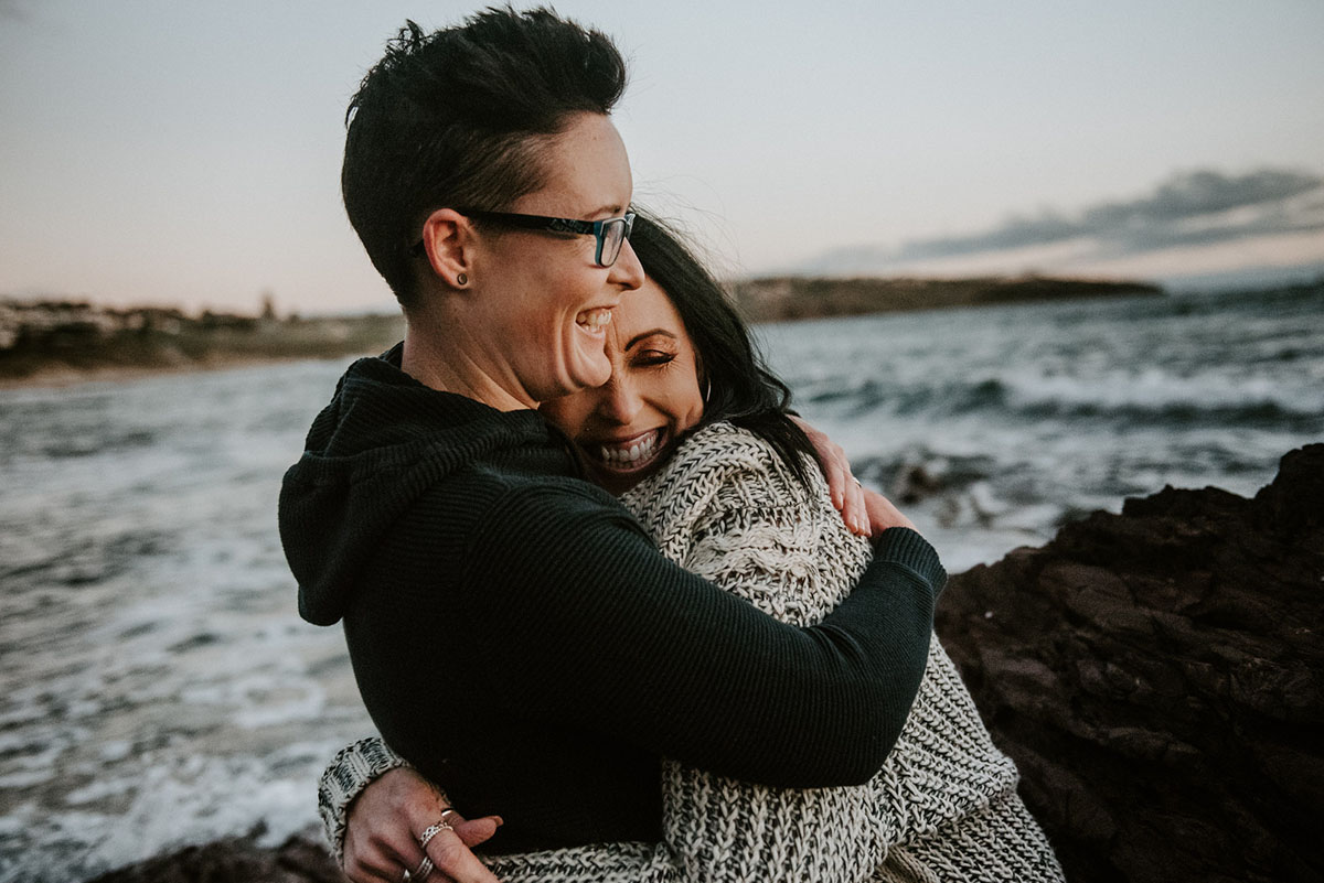 Same-sex engagement photography session on the coast of South Australia beach hugs cuddle