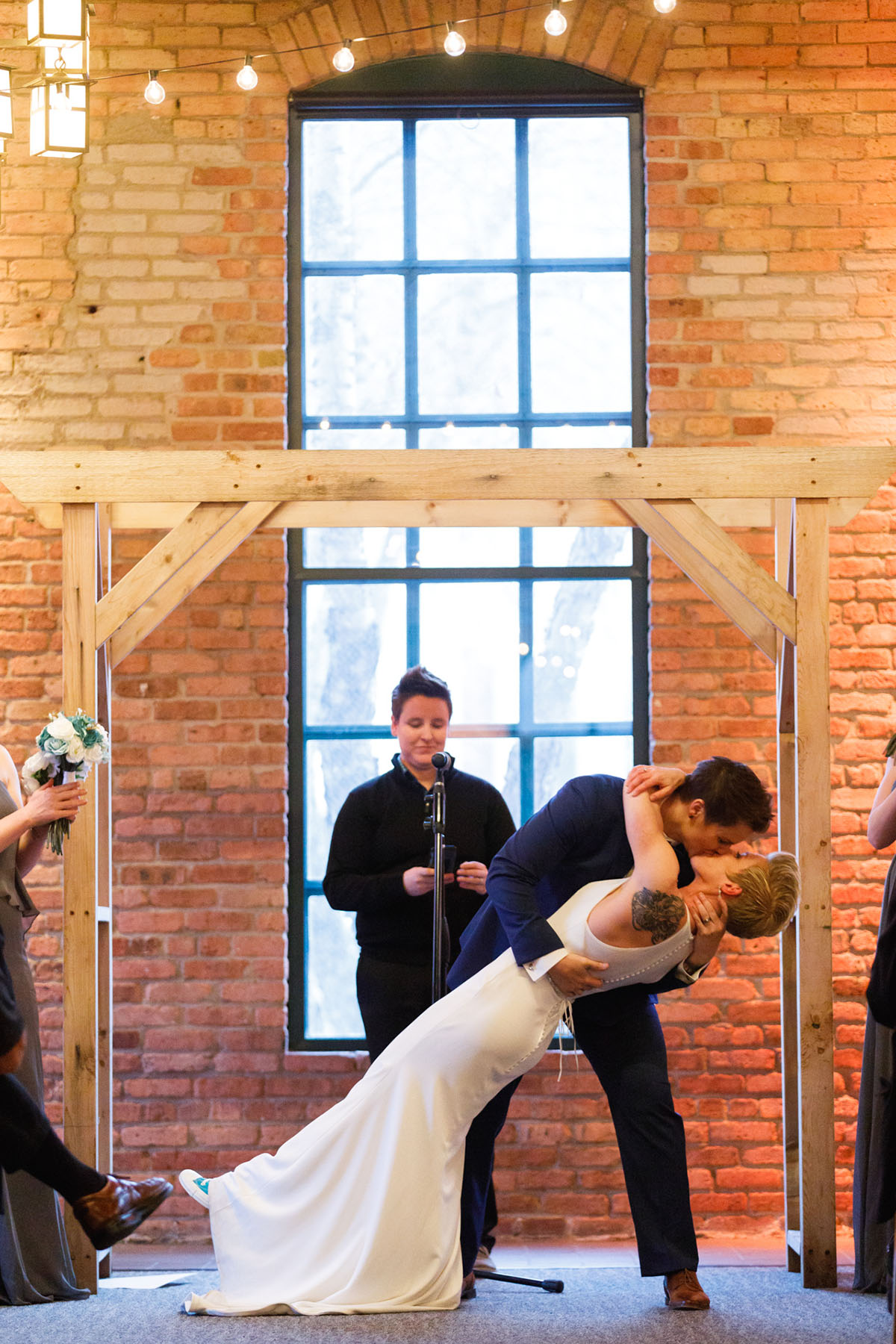Classy, modern Friday night wedding two brides Minneapolis blue tuxedo white dress short hair dip vows