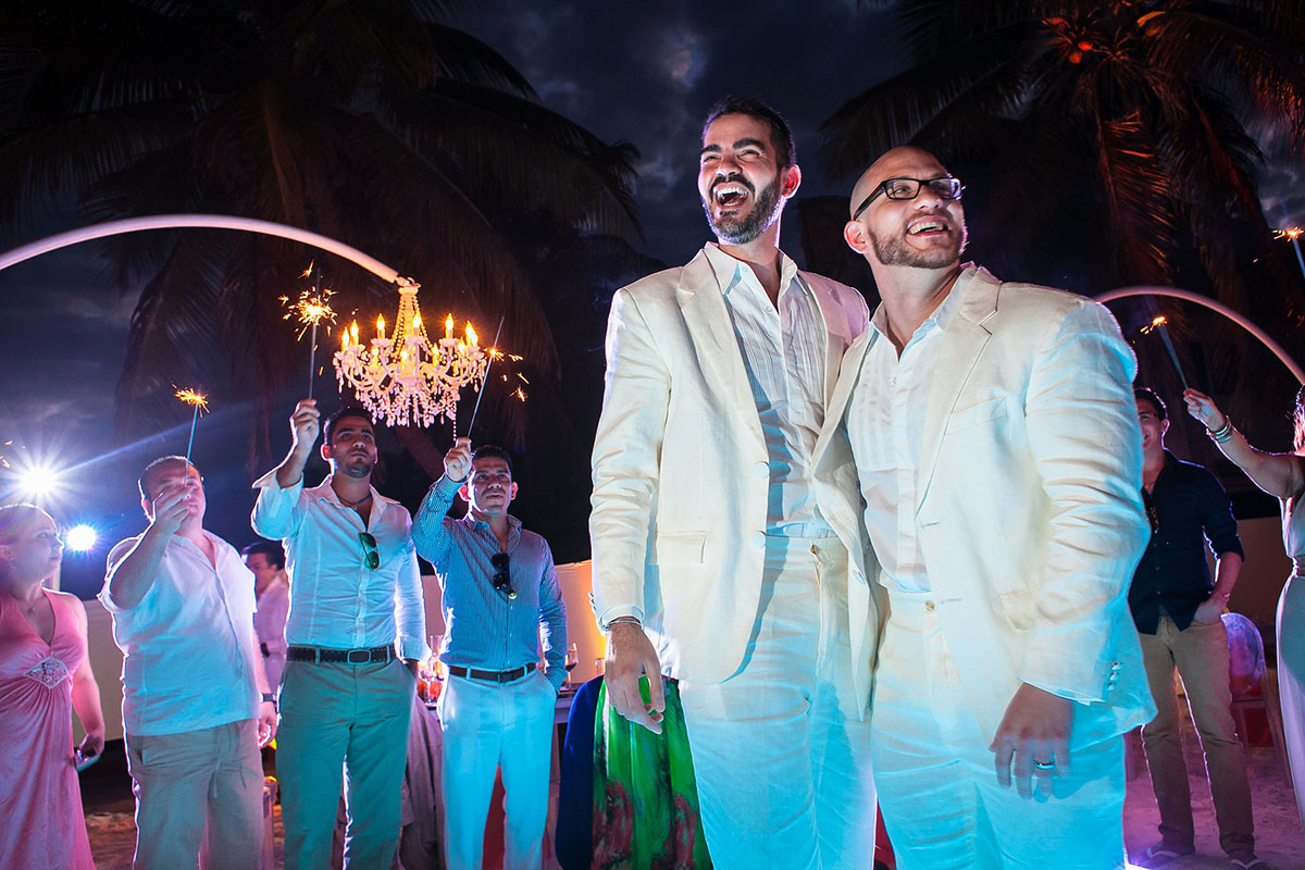 Destination Mexican beach wedding at Akiin Tulum two grooms white suits tuxedos sparklers