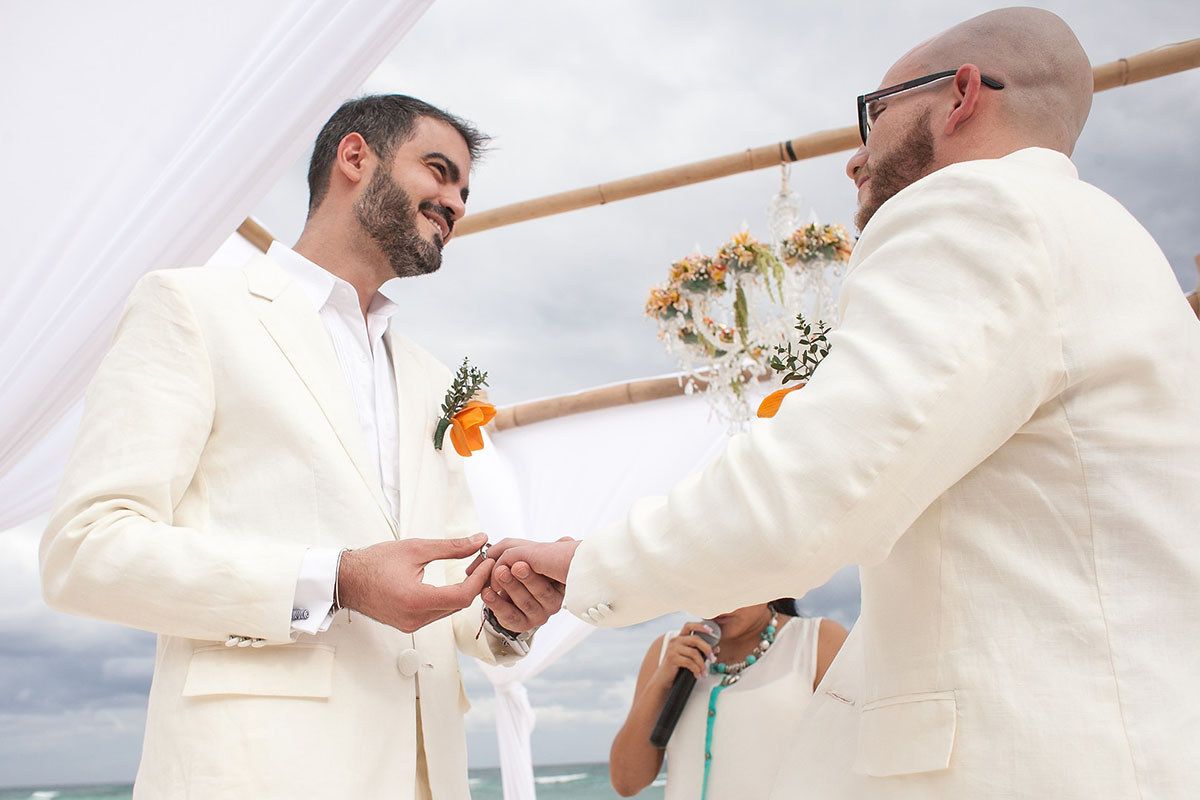 Destination Mexican beach wedding at Akiin Tulum two grooms white suits tuxedos love rings vows