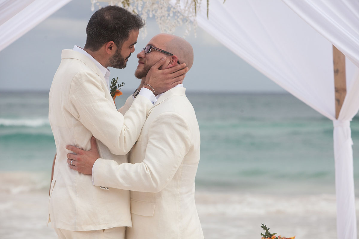Destination Mexican beach wedding at Akiin Tulum two grooms white suits tuxedos intimate