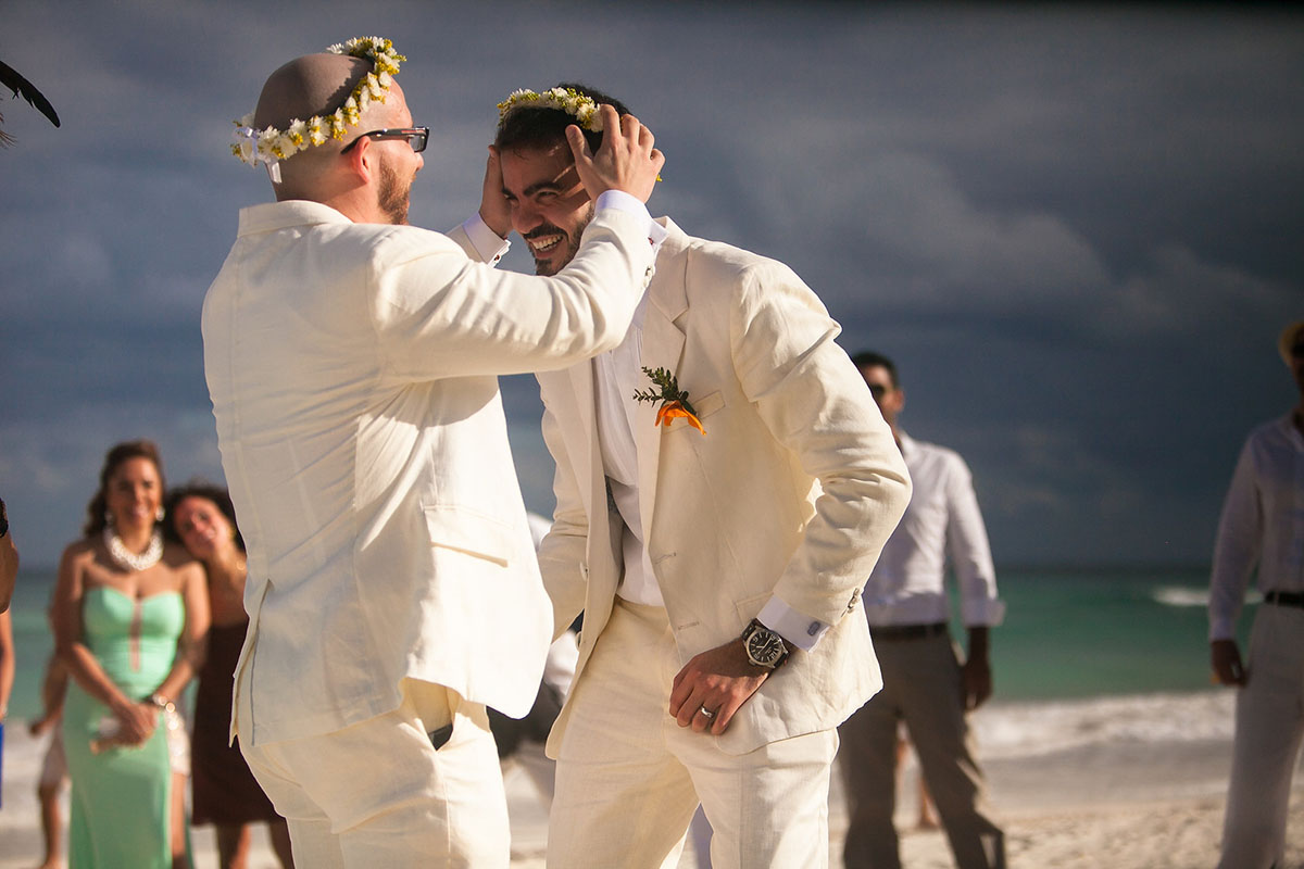 Destination Mexican beach wedding at Akiin Tulum two grooms white suits tuxedos flower crowns