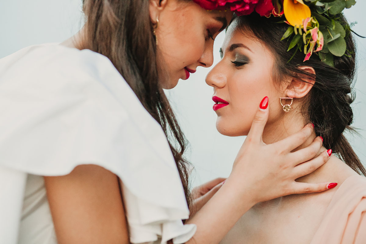 Eclectic colorful Frida Kahlo beach wedding inspiration two bridges big bouquets bright flowers classic white dresses