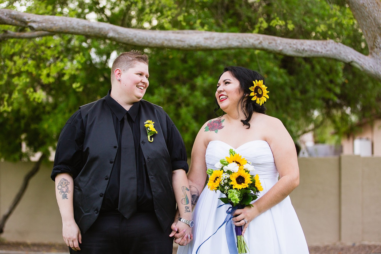 Fun and romantic Arizona backyard wedding lesbian two brides sunflowers bouquet tuxedo white dress
