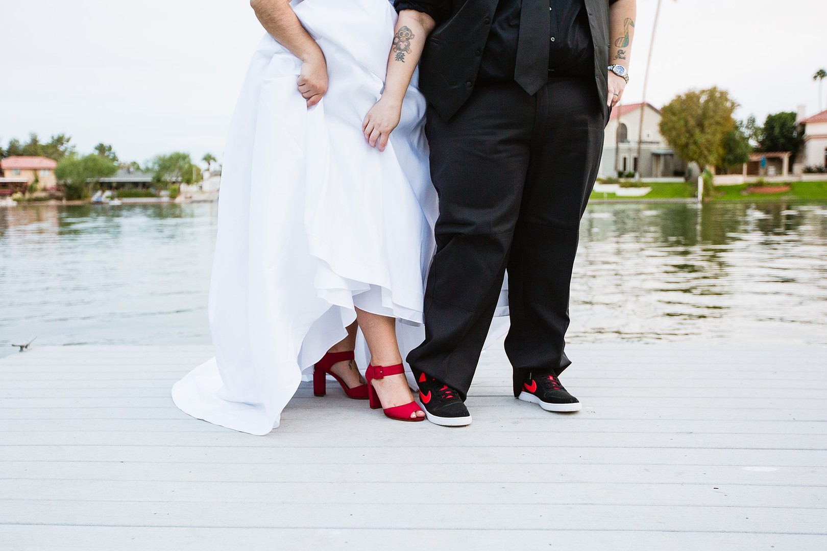 Fun and romantic Arizona backyard wedding lesbian two brides sunflowers bouquet tuxedo white dress red heels sneakers