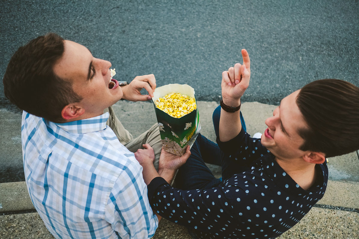Fun, whimsical movie theater engagement popcorn two grooms