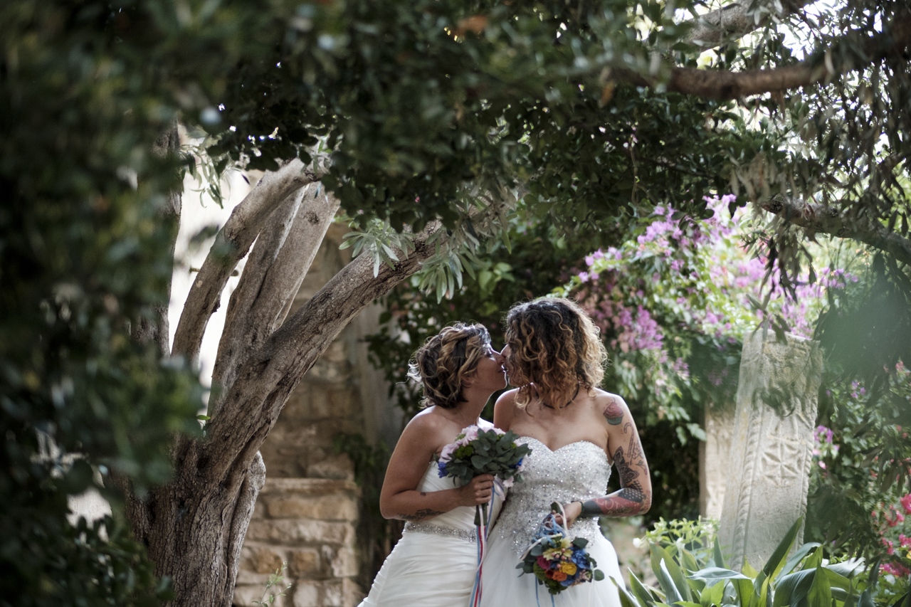 Rainbow Italian wedding in Cagliari two brides colorful bright colors short hair white dresses kiss nature