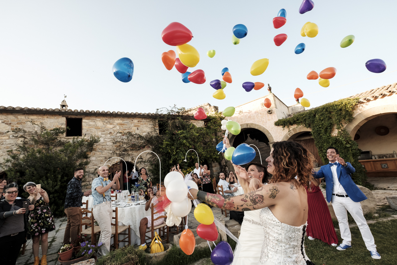 Rainbow Italian wedding in Cagliari two brides colorful bright colors short hair white dresses balloons