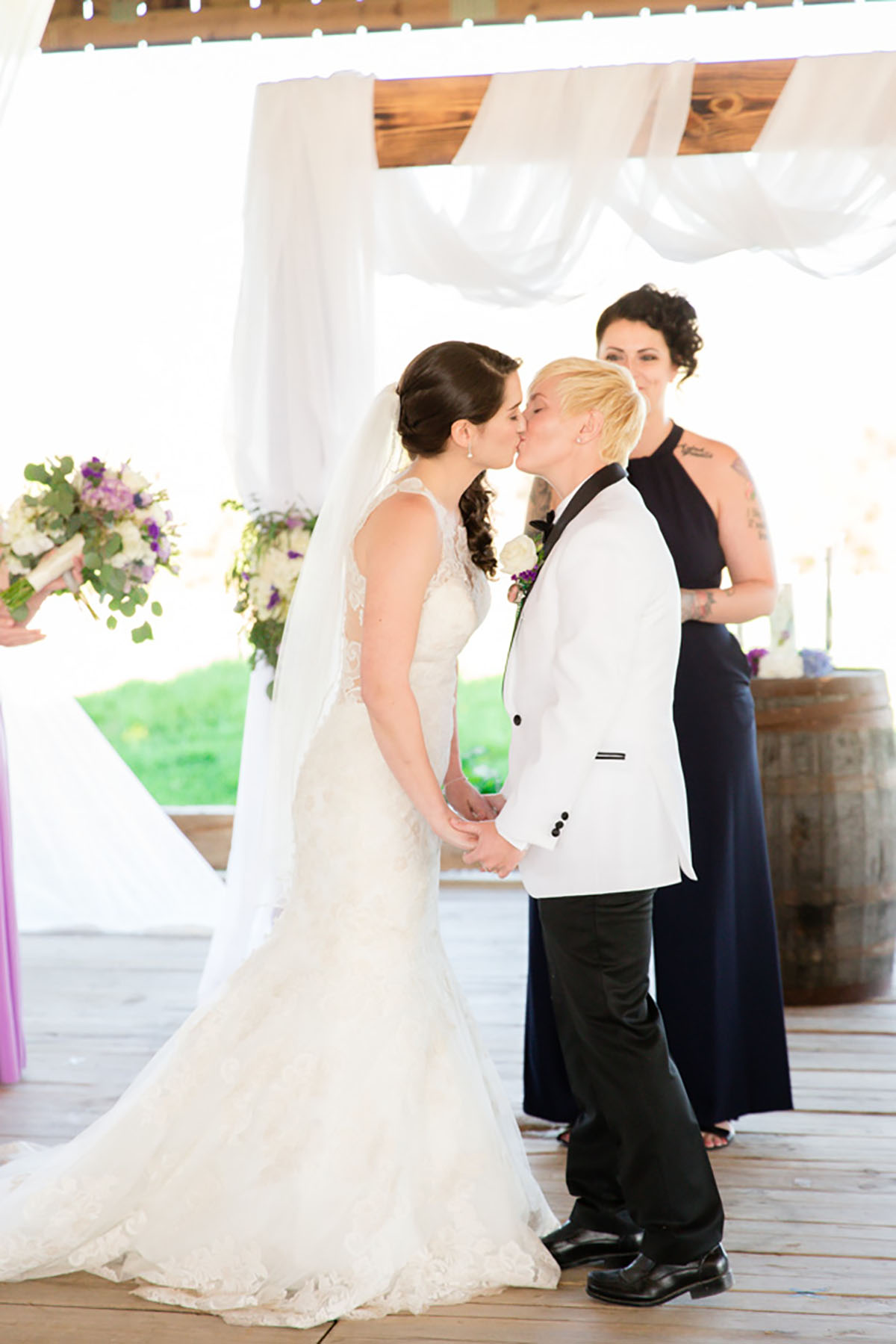 Rustic spring Kentucky farm wedding kiss two brides tuxedo lace dress