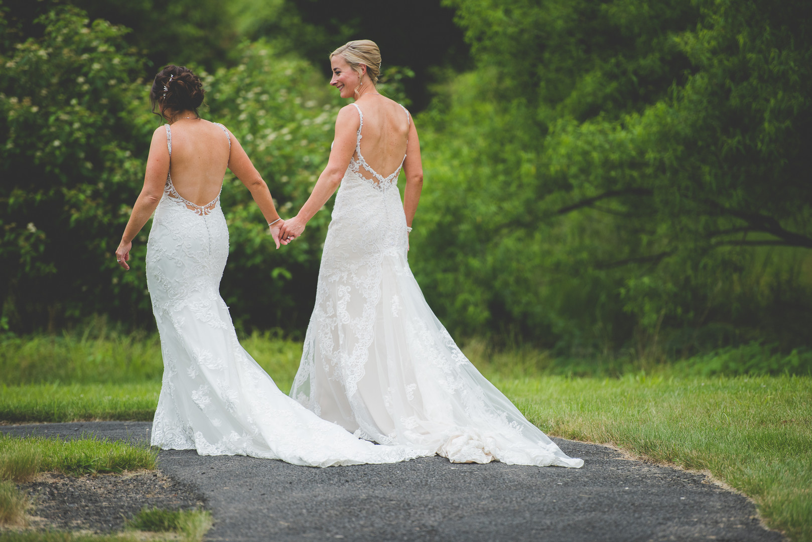 Traditional Jewish wedding during Pride Month two brides up-do long white lace dresses