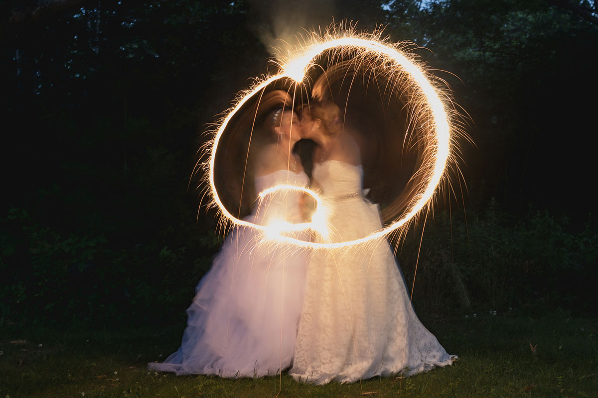 Beach wedding in Kennebunkport, Maine two brides long white dresses sparkler exit
