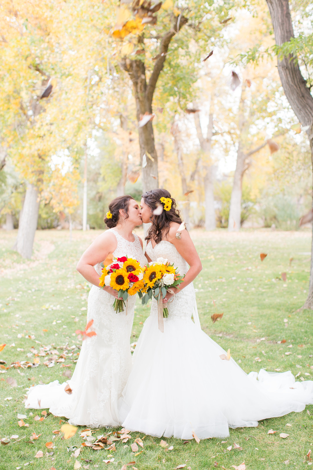 Bright fall sunflower wedding two brides autumn white lace dresses bouquet foliage leaves falling