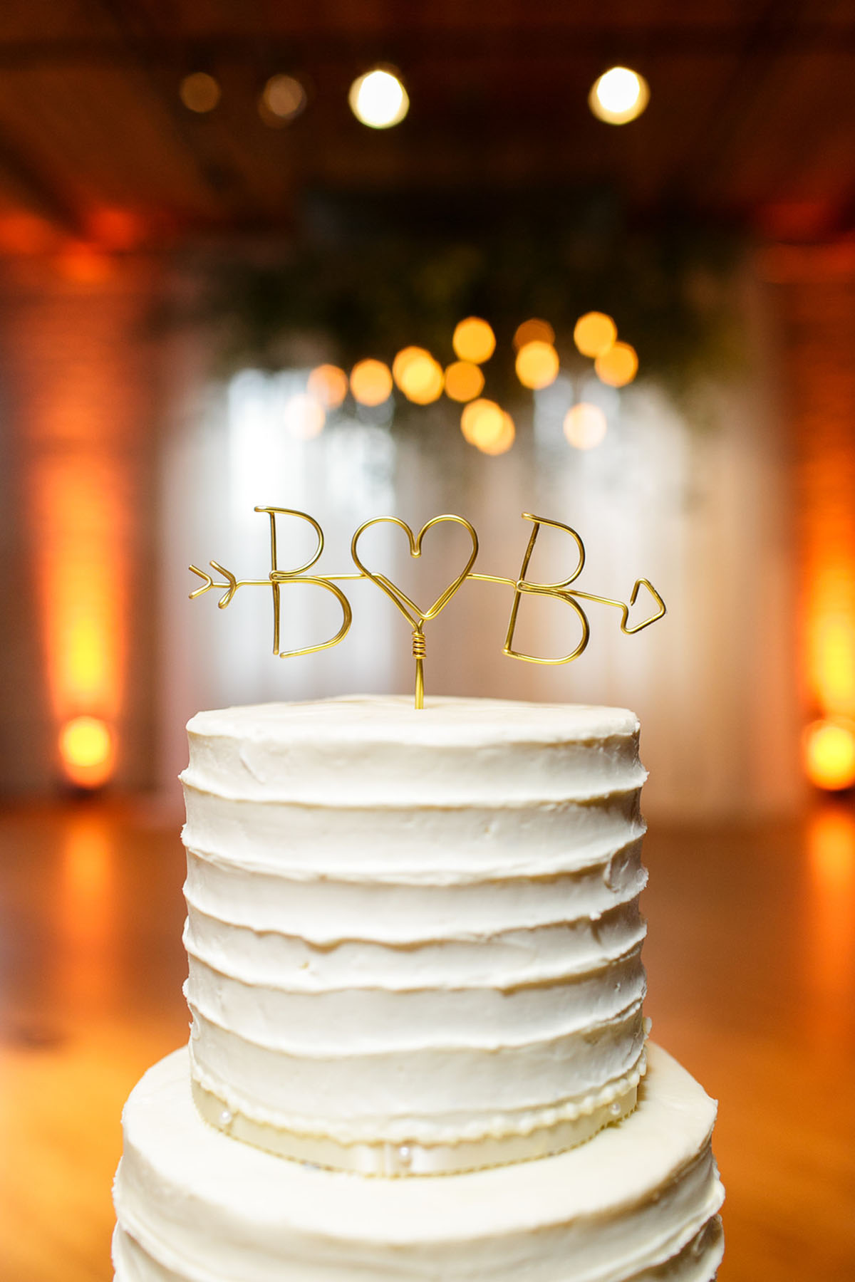 Fall wedding with navy, green, and orange colors cream and gold wedding cake arrow cake topper
