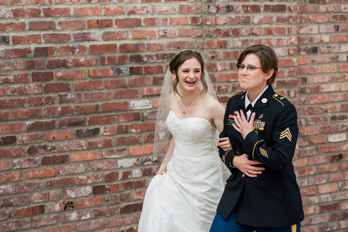 Modern Jewish military wedding exposed brick historic Tacoma Washington two brides white dress veil uniform
