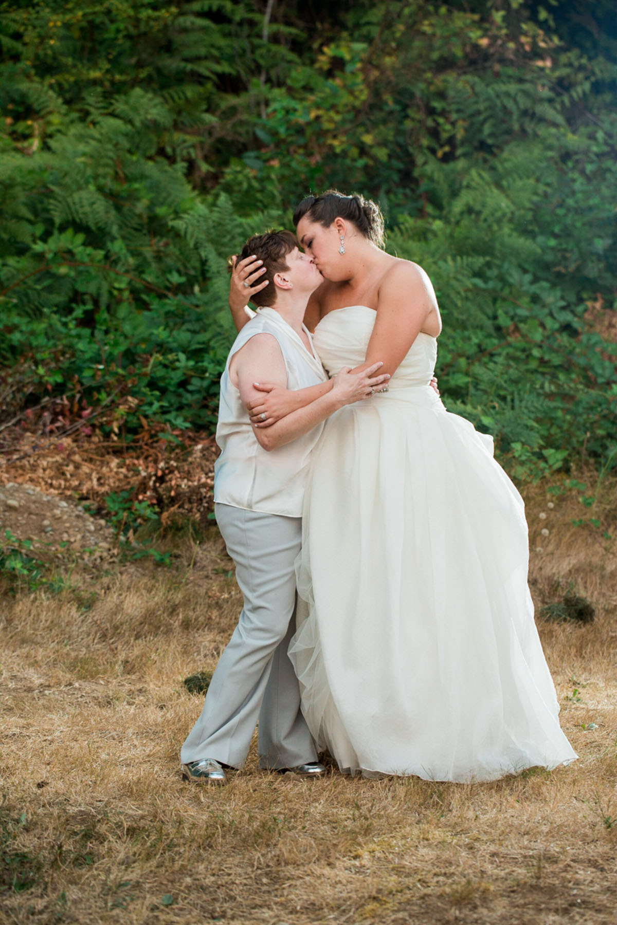 Purple Northwest backyard wedding two brides white dress white tuxedo woods kiss