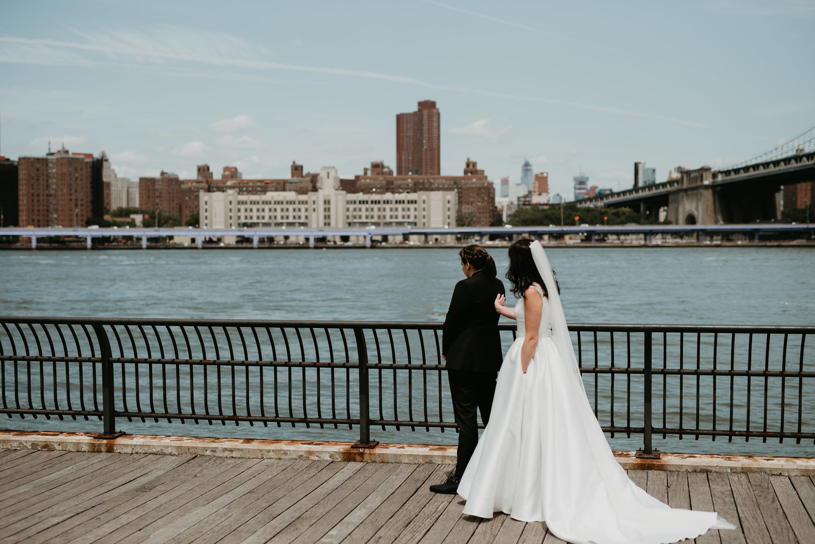 Purple and black rooftop wedding in Brooklyn, New York two brides black tuxedo V-neck white dress sunset skyline first look