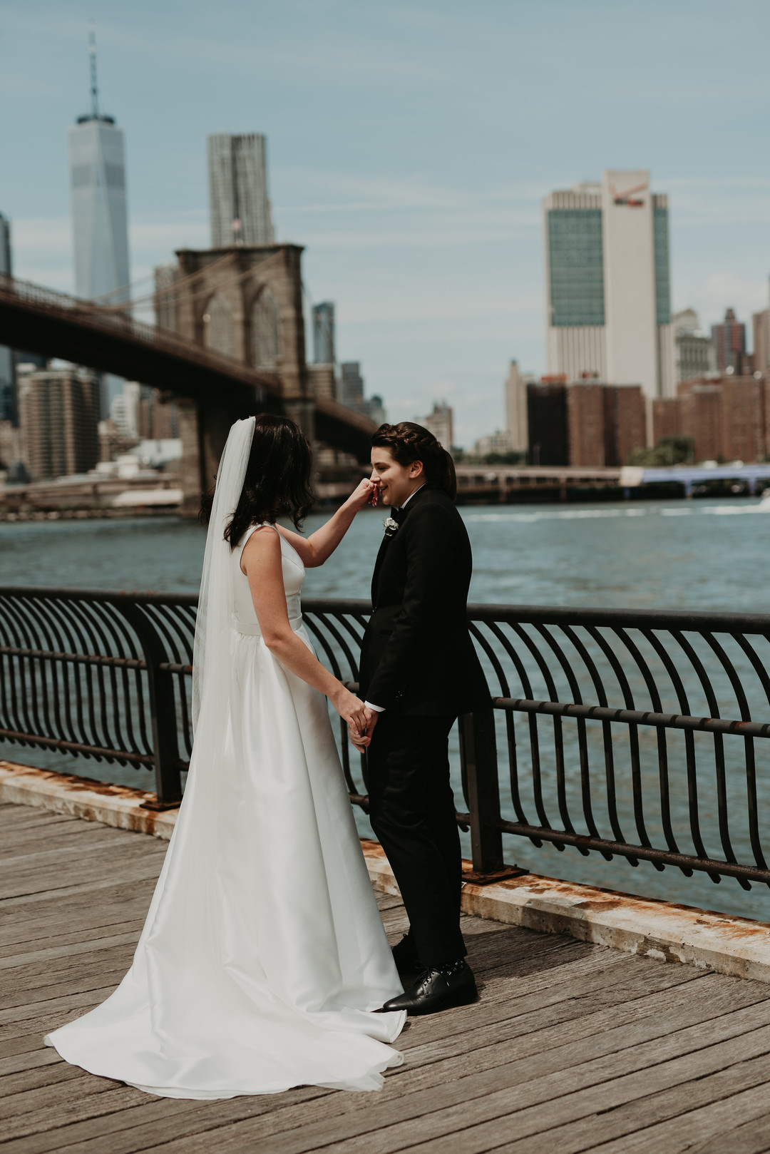 Purple and black rooftop wedding in Brooklyn, New York two brides black tuxedo V-neck white dress sunset skyline first look