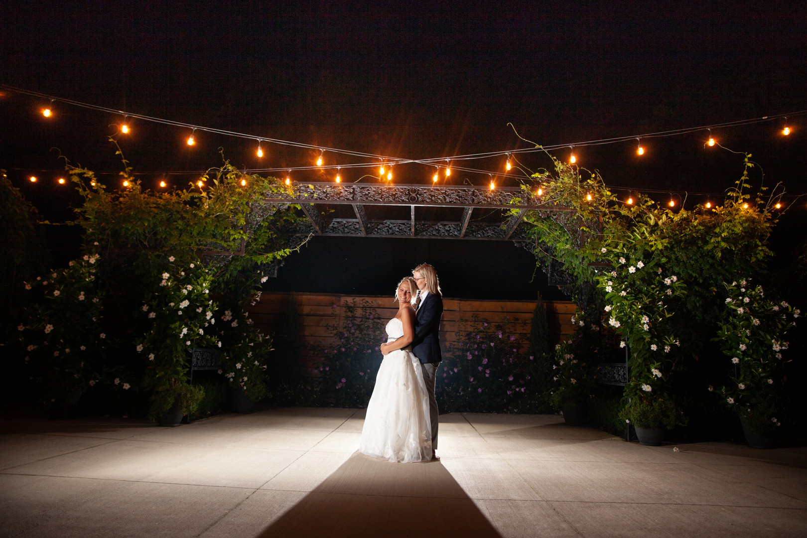 Rustic wedding in Columbus, Ohio two brides long white dress black suit outside fairy lights