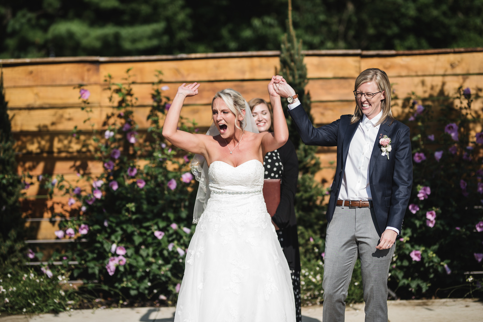 Rustic wedding in Columbus, Ohio two brides long white dress black suit outside just married