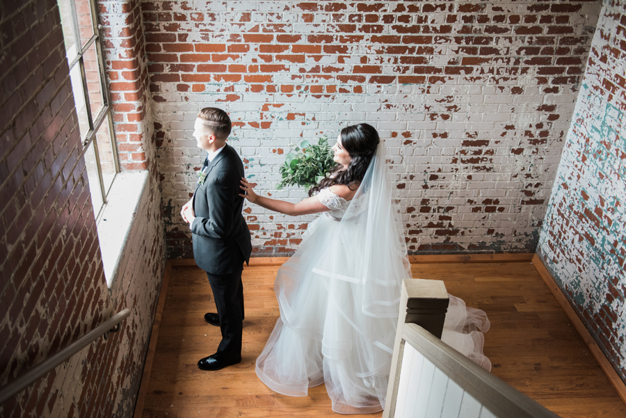 Vintage travel inspired wedding in Monroe, Georgia exposed brick industrial building two brides long white dress veil black tuxedo