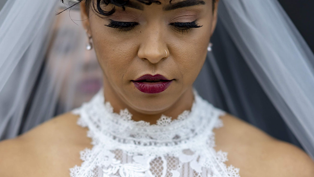 Artistic, cultural wedding in an art gallery bride in lace white dress and veil close up