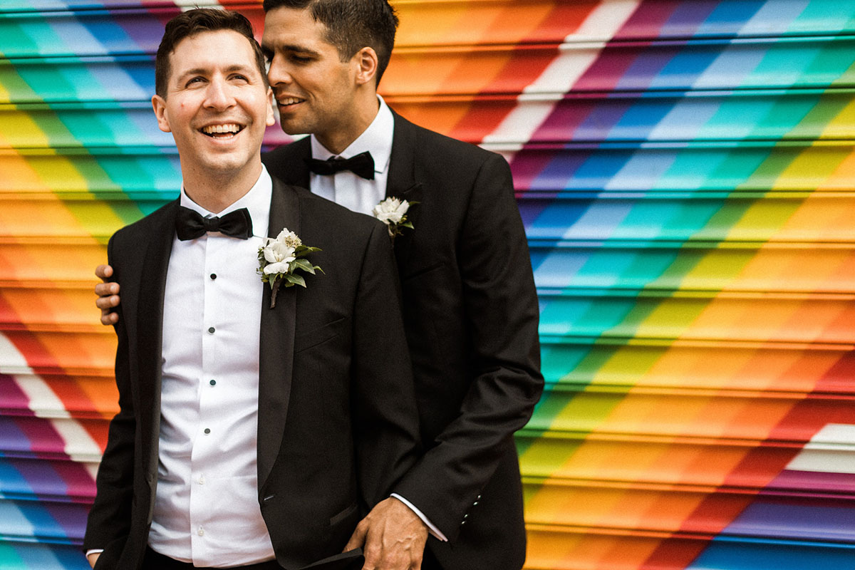 Energetic, colorful wedding in Washington, D.C. two grooms bow ties black tuxedos rainbow