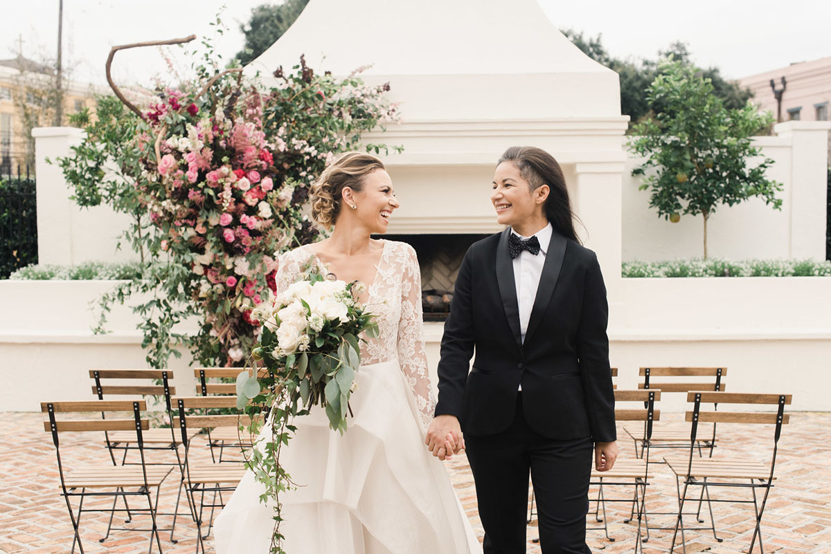 Floral wedding inspiration in New Orleans, Louisiana two brides black tuxedo bow tie long sleeve lace white dress blush rose bouquet
