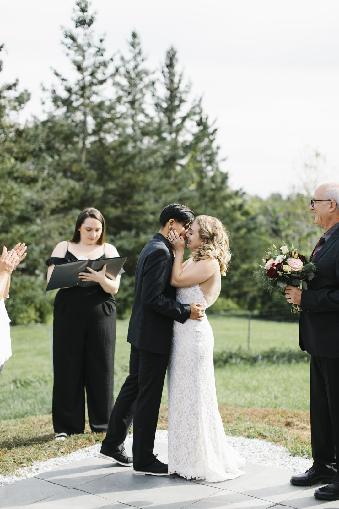 Intimate fall backyard wedding in Brandon, Vermont two brides black tuxedo burgundy bow tie strapless lace white dress braided hair kiss