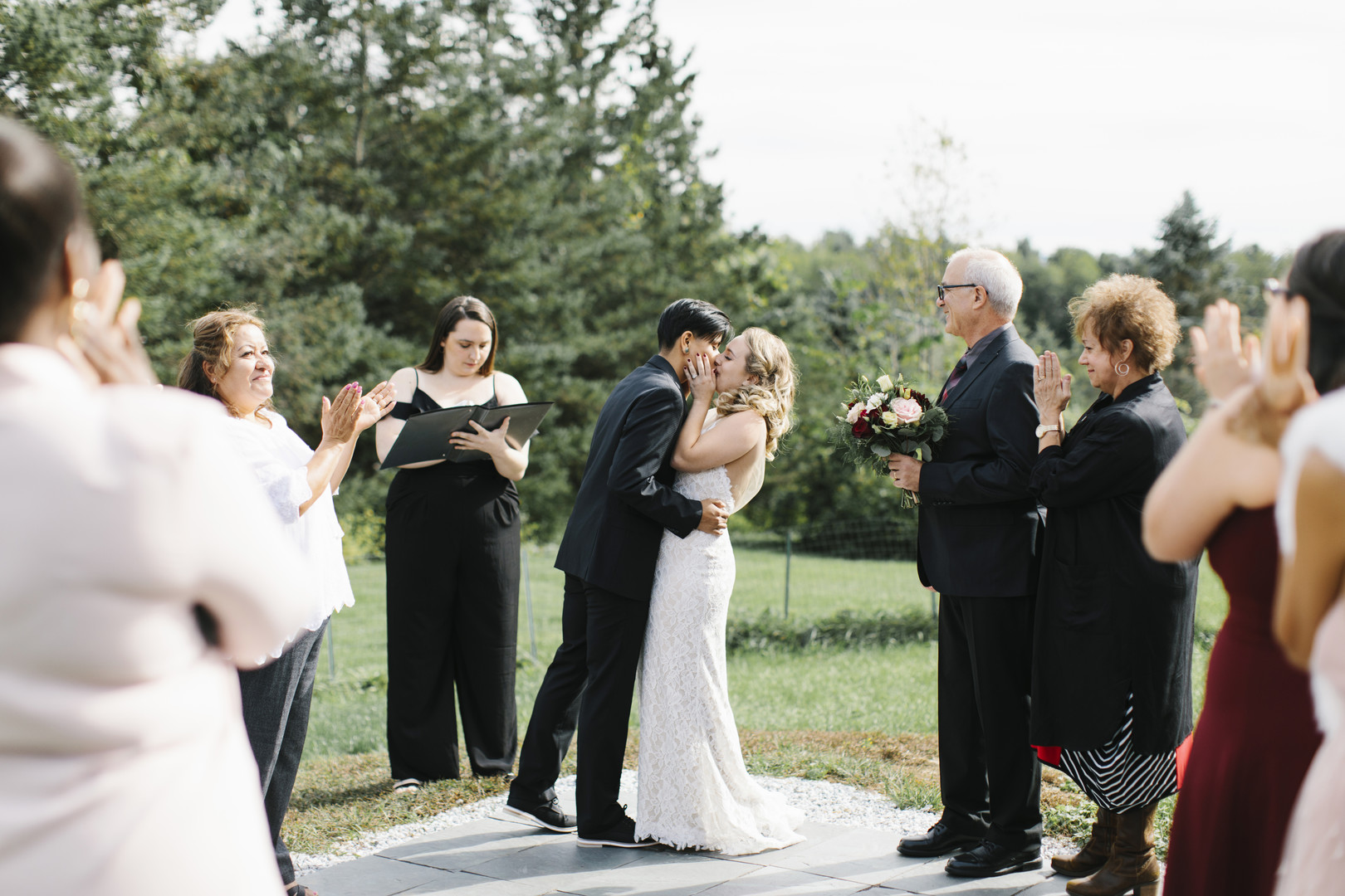 Intimate fall backyard wedding in Brandon, Vermont two brides black tuxedo burgundy bow tie strapless lace white dress braided hair kiss