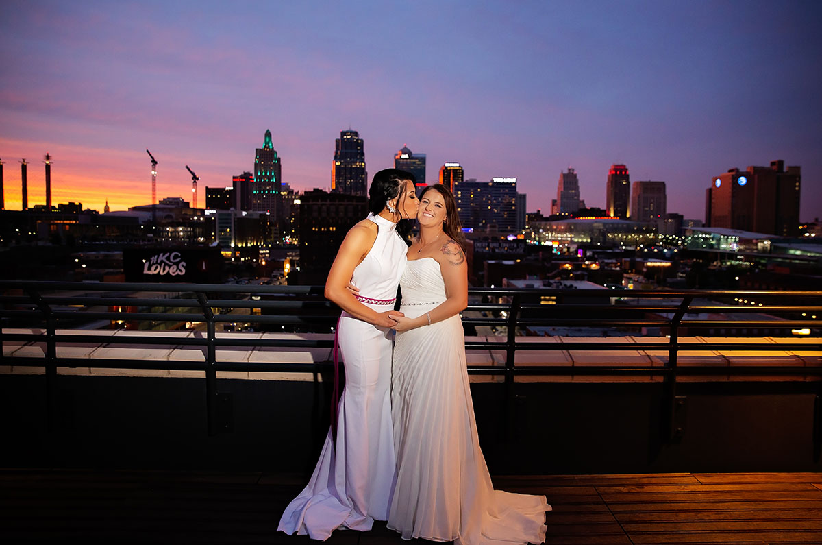 Modern rooftop wedding in Kansas City, Kansas Asian-American lesbian wedding long white dresses skyline city