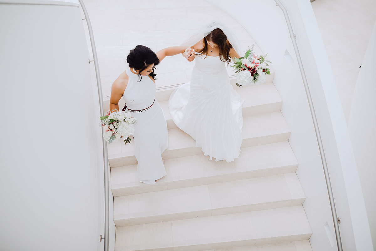 Modern rooftop wedding in Kansas City, Kansas Asian-American lesbian wedding long white dresses staircase