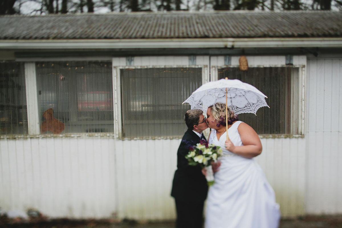 Purple greenhouse wedding with goats two brides lesbian wedding black tuxedo white dress umbrella parasol